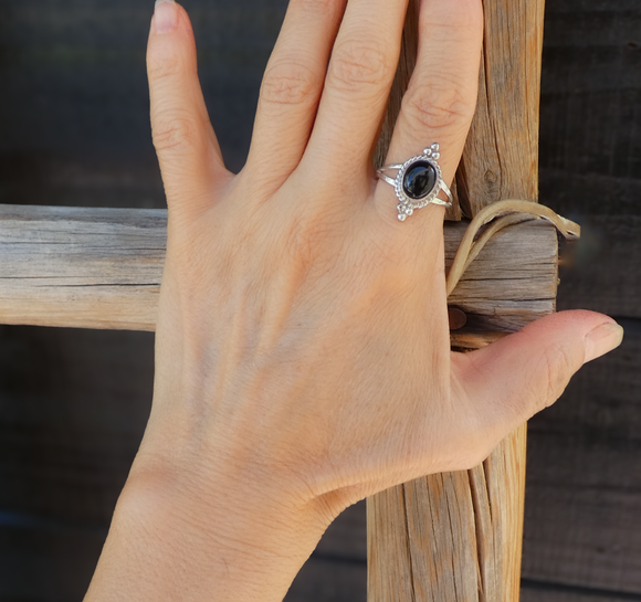 Simple sterling silver Navajo handmade women's ring in a size 9. The onyx is oval shaped with silver accents, 3 dots at the top and bottom of the oval setting.